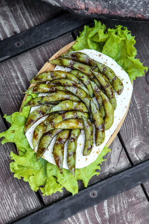 A plate containing a generous serving of fresh lettuce is placed on a sturdy wooden table.の写真素材