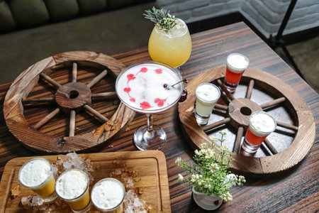 A wooden table showcasing a variety of drinks, including cocktails, sodas, and juices.の写真素材