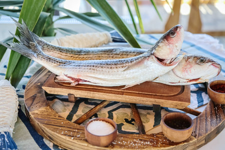 A photo showcasing two fish sitting on top of a wooden tray.