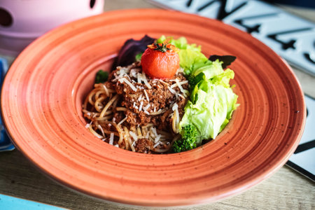 A plate of appetizing food, including various dishes, arranged neatly on a table next to a steaming cup of coffee.の写真素材