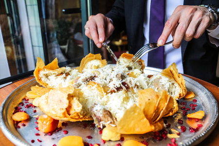 A professional man in a suit cuts into his food with precision and skill.の写真素材
