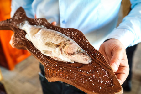 A person holds a delicious slice of pizza in their hand, ready to take a bite.の写真素材