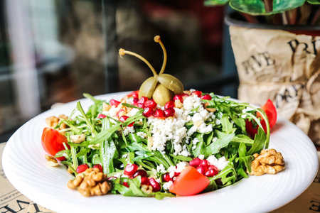 A white plate featuring a salad covered in an assortment of nuts for added crunch and flavor.の写真素材