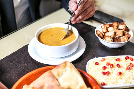 A table displaying an assortment of food, including plates filled with tasty dishes and bowls containing delicious soup.の写真素材