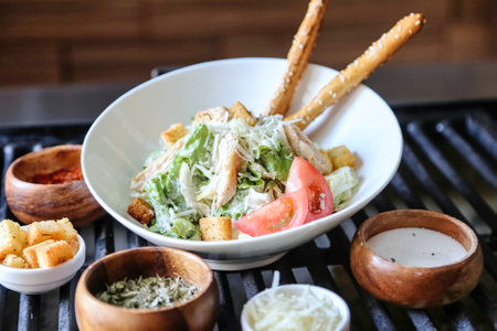 A bowl of salad and various dipping sauces grilling on a barbecue.の写真素材