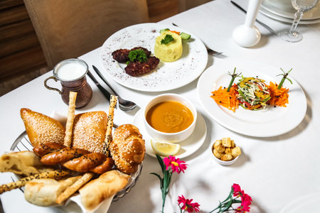 A white table is adorned with a variety of plates filled with delectable food.