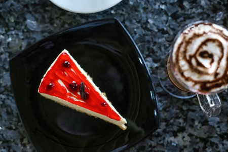 A mouthwatering slice of cake resting on a plate alongside a steaming cup of coffee.の写真素材