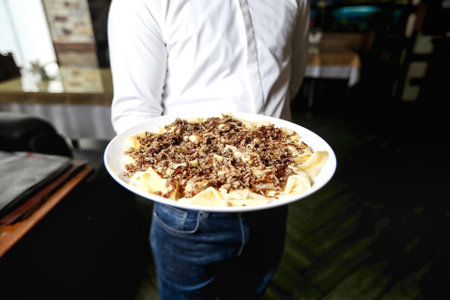 A man holds a plate filled with food in his hands.の写真素材