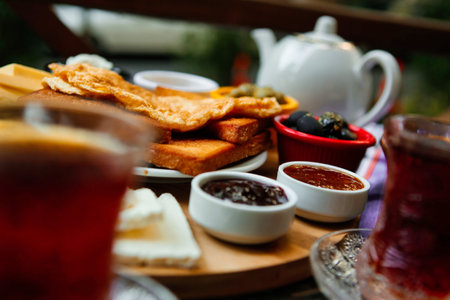 A traditional Turkish breakfast featuring tea, bread, and various spreads.