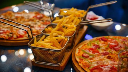 A close-up of a wooden platter with three baskets of golden French fries and two slices of pizza.