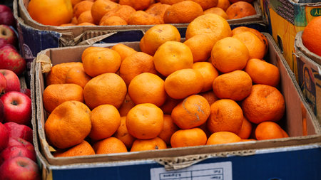 A cardboard box filled with ripe oranges.の写真素材