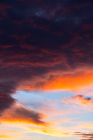 The sky transforms with stunning hues of orange and purple as the sun sets on the horizon, casting a...
