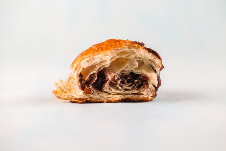 This delicious pastry reveals a flaky exterior and a rich chocolate filling, showing the perfect blend of textures and flavors ideal for a sweet treat.の写真素材