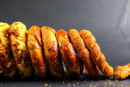 Freshly baked breads line up in a tempting display, showing diverse textures and colors. Each loaf...