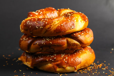 Three golden-brown pretzels stacked atop each other create a tempting display. The soft, shiny...
