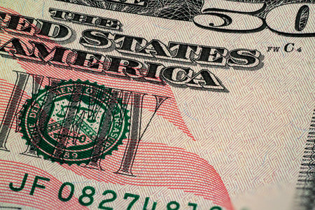 Close-up of a fifty dollar bill showing the vibrant colors and meticulous details, including the portrait and security features, highlighting American currency design.の写真素材