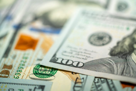Stacks of different currency bills are spread out on a flat surface, showing the intricate designs...