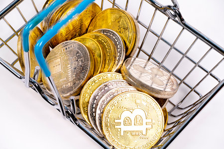 A shopping cart filled with various cryptocurrency coins, representing the growing trend of digital currency purchase options in modern commerce and finance.の写真素材