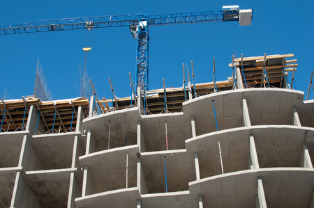 Construction crane on concrete frame buildingの写真素材