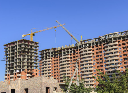 Monolith-brick residential complex under construction and high-rise cranes.のeditorial素材