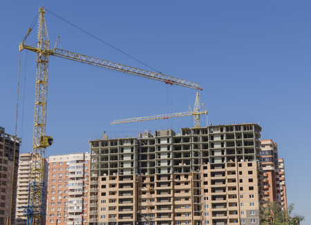 Yellow construction cranes on new buildings.の写真素材