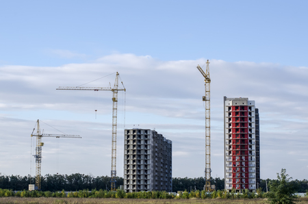 High-rise building constructed in different colors on the grass field.の写真素材