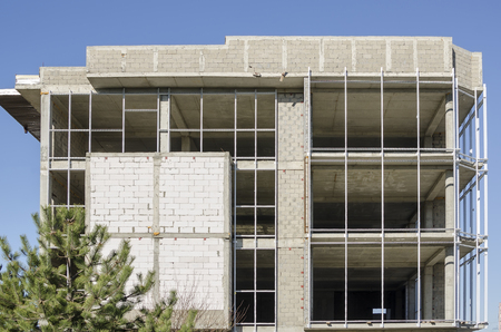 The facade of gray brick house under construction on the sky backgroundの写真素材