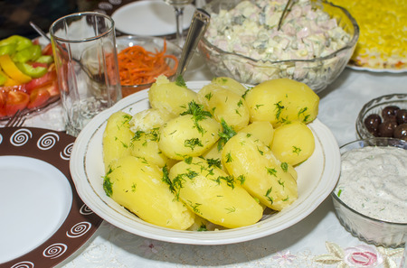 A dish of boiled potatoes with greens closeupの写真素材
