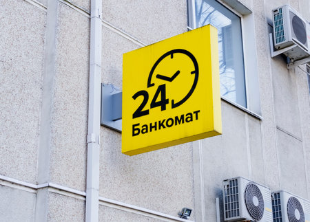 Yellow ATM pointer on the gray wall of a building