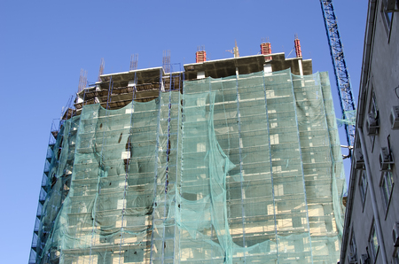 High-rise house under construction with scaffolding and a protection gridのeditorial素材