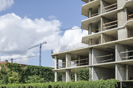 Frame of a building and three building buildings against a background of clouds.の写真素材