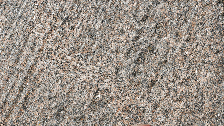 Background of uniform pinkish-gray coarse-crystalline granite close up.の写真素材