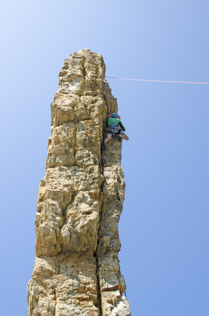 The mountaineer in the helmet ascends along a narrow vertical slope.の写真素材