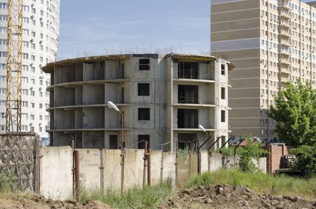 A round building under construction from monolithic concrete against the background of new houses and the sky.の写真素材