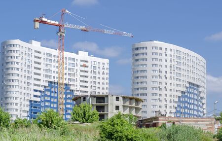 White new buildings with a round house and a tower crane in the foreground.の写真素材