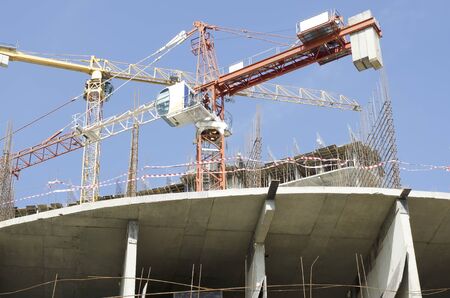 Crossed boom construction cranes on the floor under construction at home. Bottom view.の写真素材