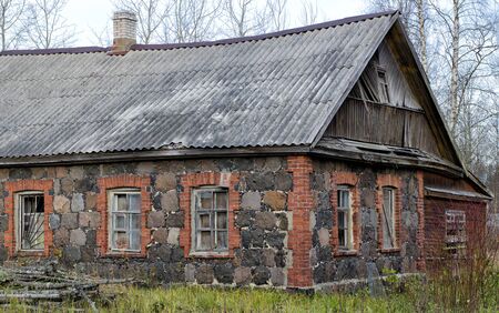An old non-residential house with walls of granite and brick fragments located in the forest.の写真素材