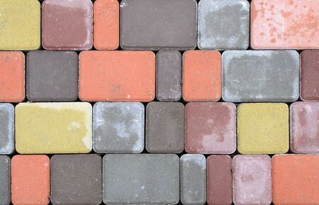 Background of densely stacked vertical stone blocks of yellow, brown, gray color.の写真素材