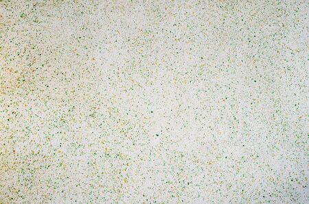 The background surface is evenly covered with numerous small spots of green and yellow.の写真素材