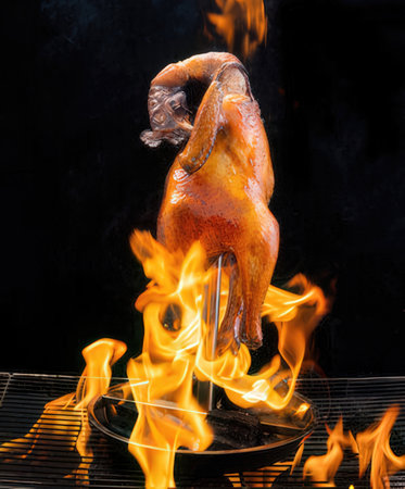 Flaming chicken on a black background with flames and smoke.の写真素材