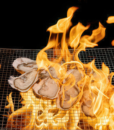 Oysters on the grill in the open air with flames.の写真素材