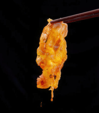 Paint dripping from chopsticks. Isolated on black background.の写真素材