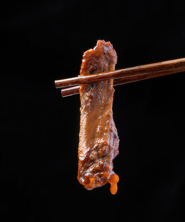 Grilled chicken on chopsticks isolated on black background with clipping pathの写真素材