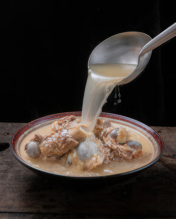 Coconut milk pouring on coconut dumpling in bowlの写真素材
