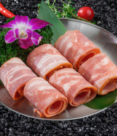 Slices of bacon on black stone background.の写真素材