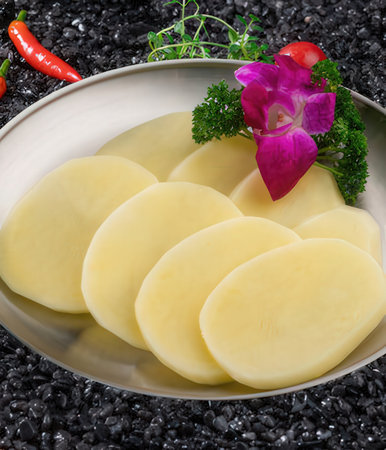 Sliced boiled potatoes on a plate with parsley and chili pepperの写真素材