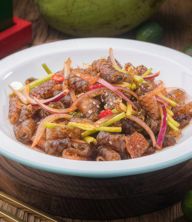 spicy stir-fried octopus with chili sauce on wooden backgroundの写真素材