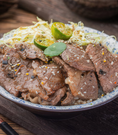 Beef sirloin with rice and vegetables in bowl on wooden tableの写真素材