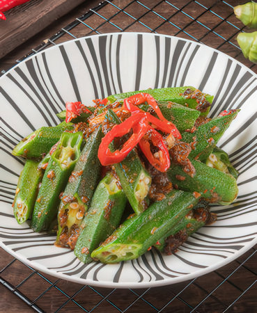 Okra salad with sesame seeds and chilli on wooden tableの写真素材