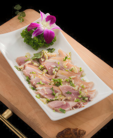 Slices of raw fish with parsley on a white plateの写真素材